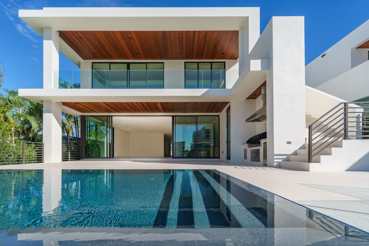 Modern white house with glass windows and pool.