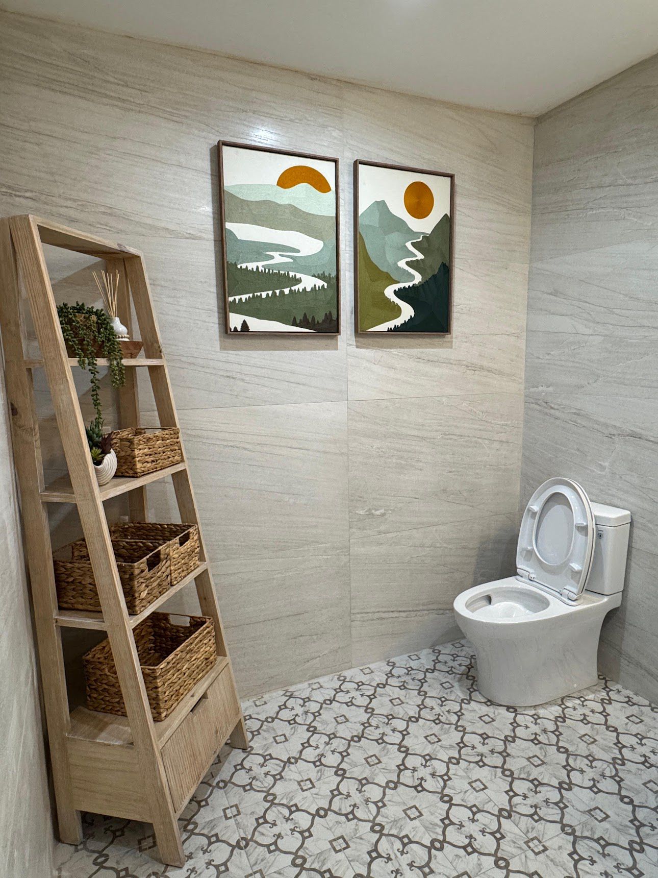 Modern bathroom with white toilet, patterned tile floor, and wood ladder shelf