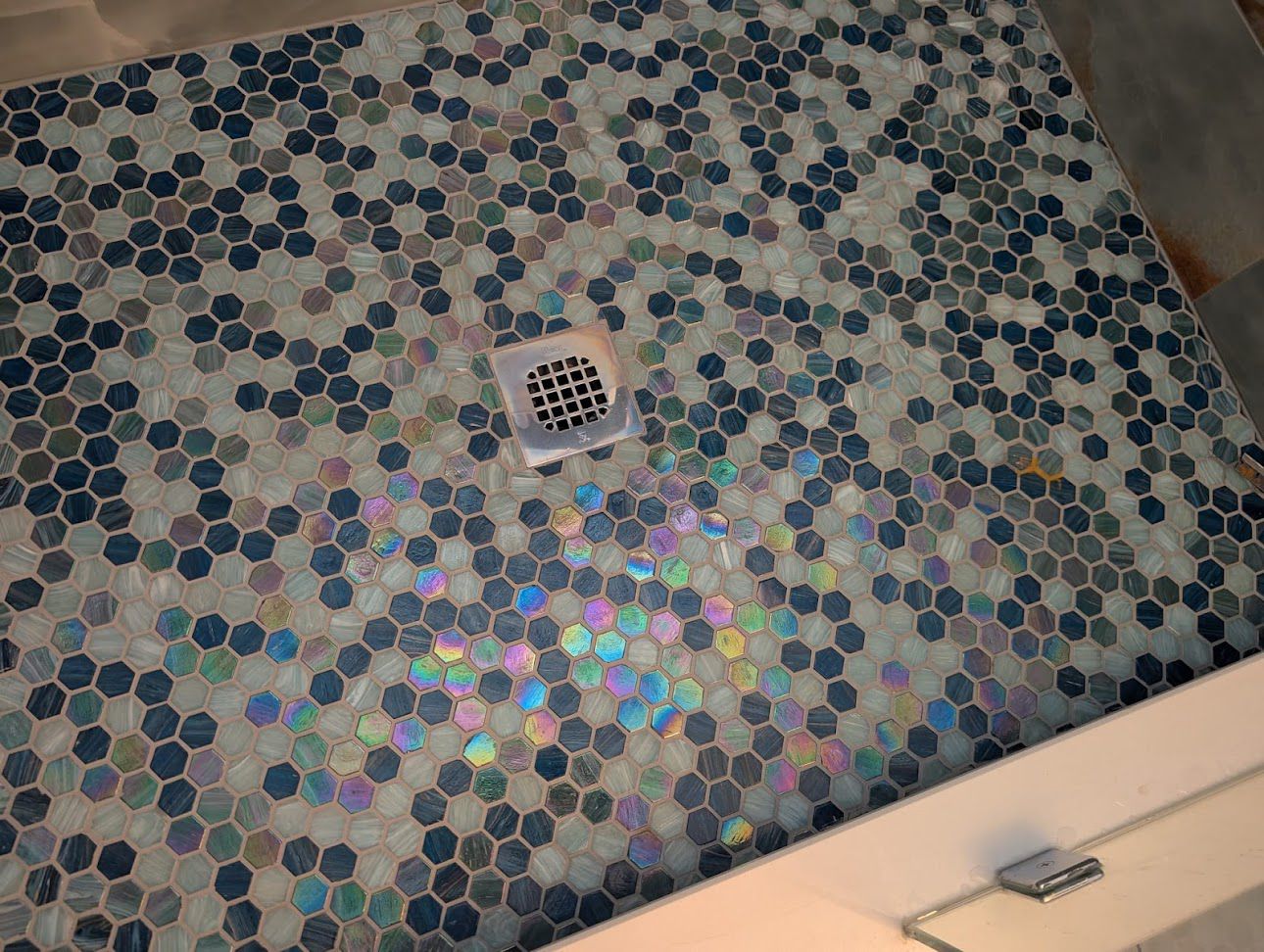Modern shower with large format blue marble look tiles and glass enclosure